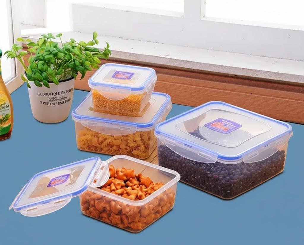 Four clear BPA-free plastic food storage containers with airtight locking lids, filled with pasta, beans, and healthy snacks